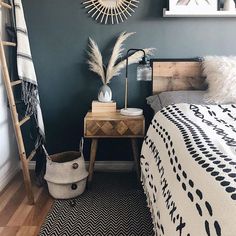 a bed room with a neatly made bed next to a wooden ladder and a plant