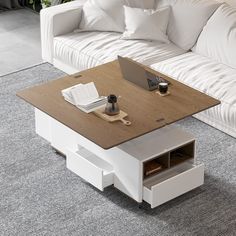 a coffee table with a laptop on it in the middle of a living room area