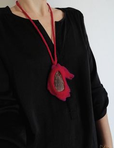 a woman wearing a black shirt and red necklace