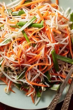 a salad with carrots, celery, and shredded cheese on a plate