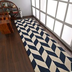 a blue and white area rug on the floor in front of a large window with lots of windows