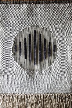 an image of some sort of weaving on a table cloth with fringes and beads