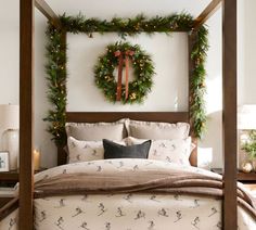 a bedroom decorated for christmas with wreaths on the headboard and lights hanging from the ceiling