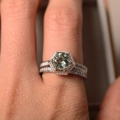 a close up of a person's hand with a diamond ring on their finger