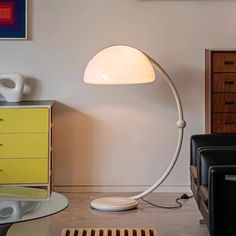 a white lamp sitting on top of a table in a living room next to a chair