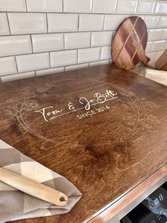 a wooden cutting board sitting on top of a counter next to a knife and spatula