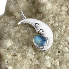 "A sterling silver pendant of a detailed crescent moon and genuine rainbow moonstone cabochon. Handmade to order as a pendant or with your choice of chain length from 16\" - 30\" inches. Each pendant is 1 1/2\" inches long x 3/4\" inch wide." Unique Moon-shaped Moonstone Necklace, Silver Crescent Moonstone Necklace, Sterling Silver Oval Moon Phase Necklace, Unique Crescent Moonstone Jewelry, Crescent Moonstone Necklace With Moon Phase Detail, Crescent Moonstone Necklace With Sun And Moon Design, Silver Half Moon Moonstone Jewelry, Crescent Moonstone Ring In Sterling Silver, Sun And Moon Design Moonstone Necklace