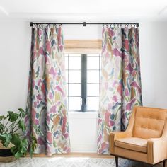 a living room with a chair, window and potted plant in front of it