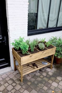 a wooden planter filled with plants next to a building