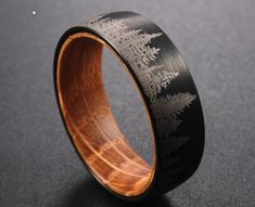 a wooden ring with an intricate design on the inside is shown in black and gold