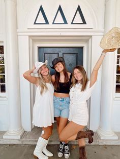 three girls are posing in front of a door