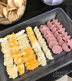 several different types of snacks are on a tray next to chips and crackers in bowls