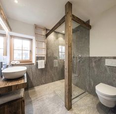 a bathroom with a toilet, sink and shower stall in the middle of the room