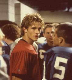 a group of young men standing next to each other on top of a football field