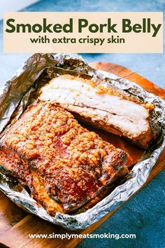 baked pork belly with extra crispy skin in foil on a wooden cutting board and text overlay that reads smoked pork belly with extra crispy skin