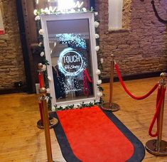 a red carpet on the ground next to a window with a touch screen sign in it