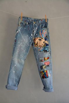 an old pair of jeans with pictures on them hanging from a clothes line