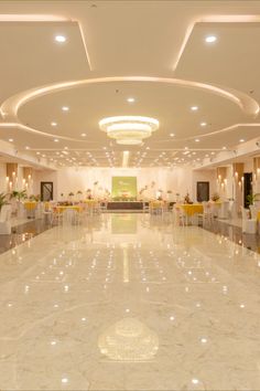 a large banquet hall with white tables and yellow chairs