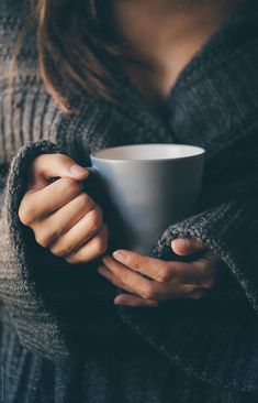 a woman holding a coffee cup in her hands