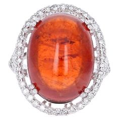 This beautiful ring has a 26.12 carat Cabochon Spessartine set in the center of the ring. A Spessartine is a natural stone that is actually a part of the Garnet family of stones. The ring is surrounded by 52 Round Brilliant Cut Diamonds that weigh 0.85 carats. The total carat weight of the ring is 26.97 carats. This ring is 14K White Gold and weighs approximately 7.5 grams. The ring is a size 6.75 and can be re-sized at no additional charge. Garnet And Diamond Ring, Eternal Beauty, Vintage Cocktail Ring, Gold Cocktail Ring, Contemporary Ring, Gold Cocktail, Vintage Cocktail, Modern Ring, Pretty Rings