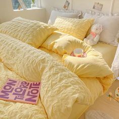 a bed with yellow comforters and pillows on it