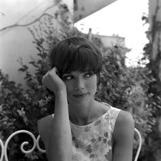 a black and white photo of a woman sitting at a table with her hand on her head