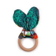 a wooden ring with a green and red patterned bow on it's end, against a white background