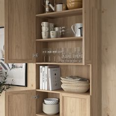 a wooden cabinet filled with dishes and wine glasses