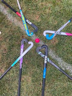 several different types of baseball bats laying on the ground with balls and bats around them