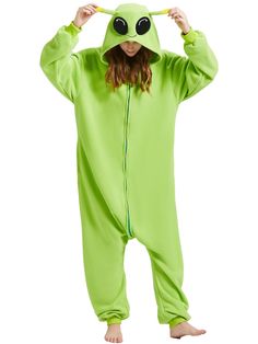 a woman in a green frog costume is holding her head with one hand and looking at the camera