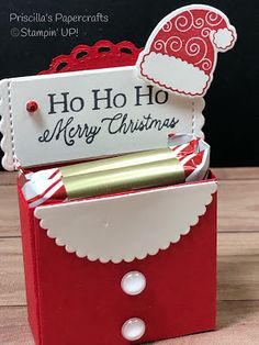 a red and white christmas card holder with a santa hat on it's head