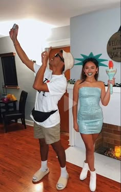 a man and woman standing next to each other in front of a fireplace holding wine glasses