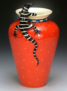 an orange vase with a lizard painted on it