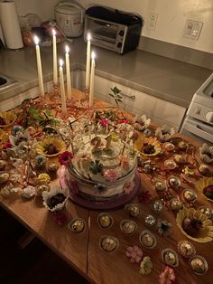 a table topped with a cake and lots of cupcakes on top of it