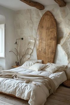 a surfboard mounted to the side of a wall above a bed in a bedroom