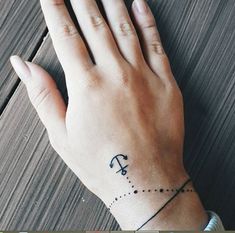 a person's hand with a small tattoo on the wrist that has an arrow