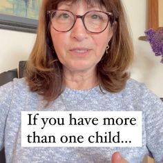 a woman with glasses holding up a sign that says if you have more than one child