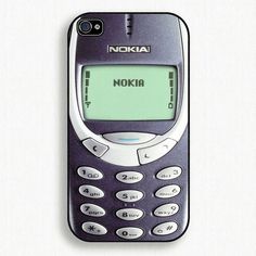 an old nokia cell phone sitting on top of a white table with the screen turned off