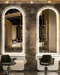 two mirrors that have lights on them in front of a hairdresser's chair