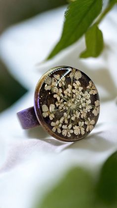 Welcoming a little piece of nature for someone unerring! Enjoy this pressed Queen Anne's Lace Ring pressed before encapsulating them with resin. Ring Measures, Tray: 16mm, 5x17mm Pendant Measures: Oval Tray: 25x18mm, 42.5x23.5x2mm, Hole: 3mm The Antique Bronze ring is adjustable and comes in a beautifulgift box.. All Jewelry findings are Lead and Nickel free. The petals have been carefully preserved to retain their color and would make a great gift for your loved ones. This piece was made with r Bohemian Brown Flower Jewelry, Bronze Flower-shaped Jewelry Gift, Vintage Copper Ring Jewelry, Handmade Brown Flower Jewelry, Bohemian Adjustable Flower Ring For Anniversary, Handmade Brown Ring For Wedding, Nature-inspired Brown Flower-shaped Jewelry, Adjustable Copper Flower Jewelry, Handmade Green Flower Ring For Weddings