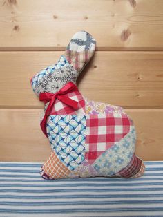 a patchwork stuffed animal sitting on top of a bed