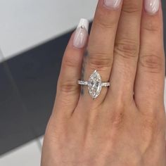 a close up of a person's hand with a diamond ring on their finger