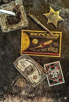 various stickers, money and pen on top of a black surface with the word rockin'n roll written on it