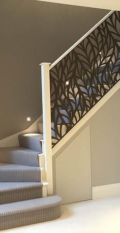 a stair case next to a set of stairs in a room with gray walls and carpet