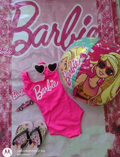 a barbie shirt, sunglasses and sandals are laying on the ground next to a bag