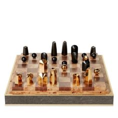 a wooden chess board with black and gold pieces on it's sides, all in different shapes and sizes