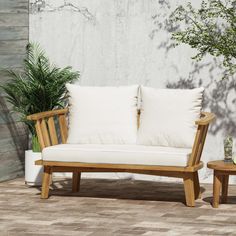 two wooden benches sitting next to each other near a planter and potted tree