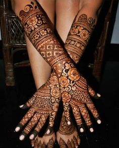 two hands with henna tattoos on them