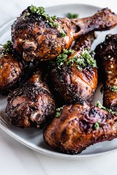 grilled chicken on a white plate with parsley