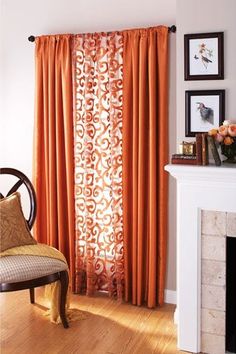 an orange curtain in front of a fireplace